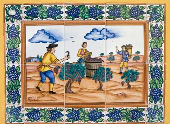 Moderna spanska keramiska plattor i stil från 1600- eller 1700-talet som visar vingårdsarbetare som skär druvklasar